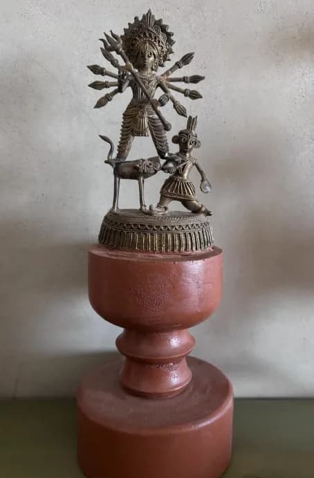Dokra Durga idol on a hand-turned wooden base