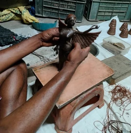 Artisan shaping a Dokra figure at Bikna, Bankura